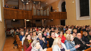 In der Kirche kommen zahlreiche Besucher zusammen.