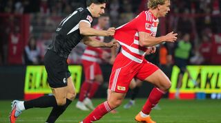 Matanovic (l.) bremst Querfeld (r.) mit unerlaubten Mitteln.