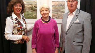 Marianne Nagel-Treiber (v.l.), Künstlerin Ingrid Eckert und Wolfgang Treiber vor den Kunstwerken „Stausee“ und „Dolomiten“.